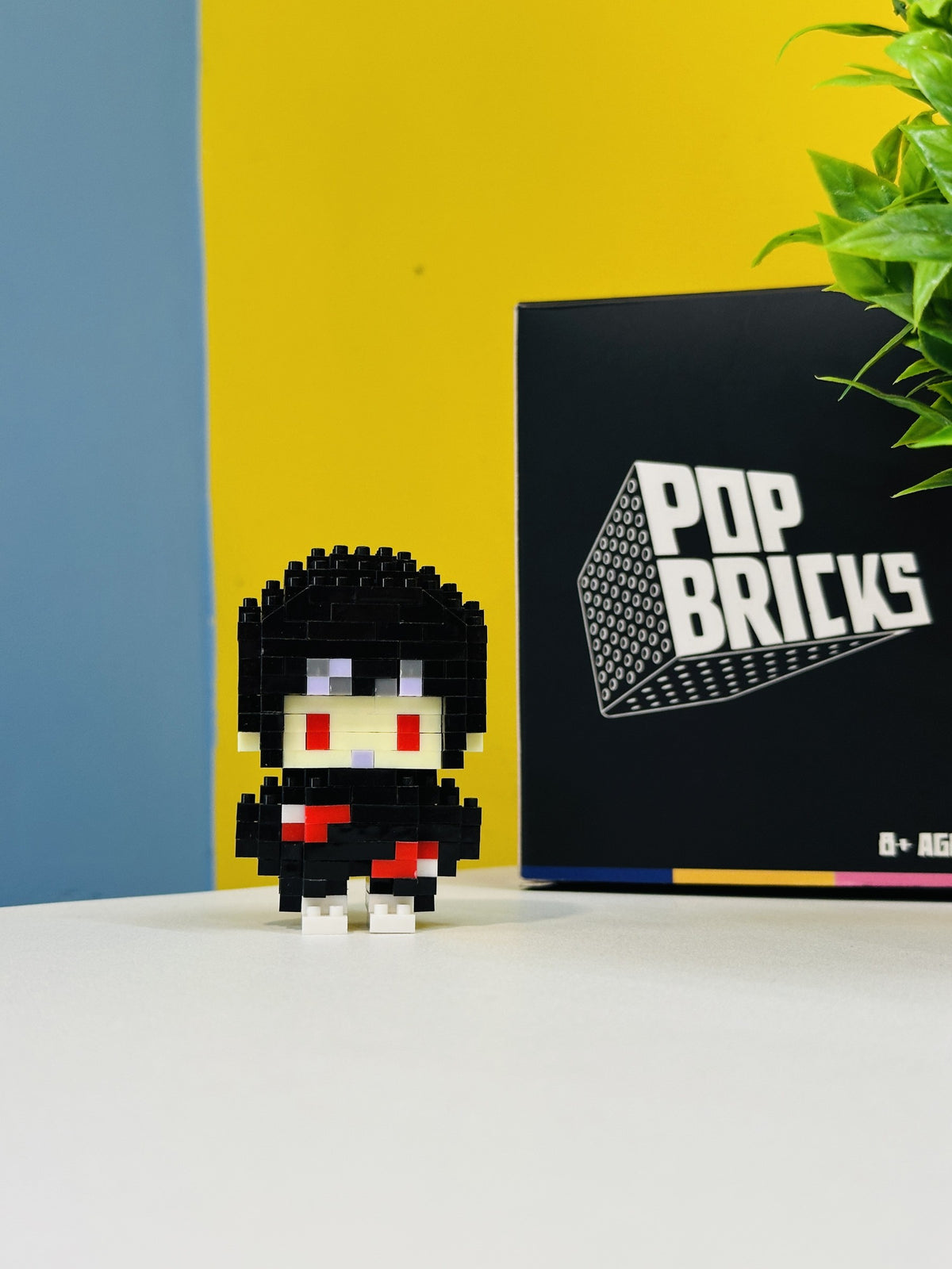 Front view of Itachi Pop Bricks mini figure with branded packaging